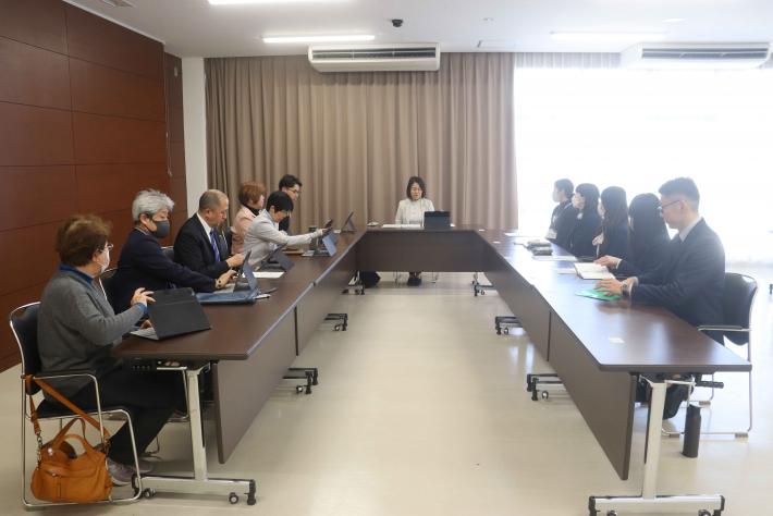 会議室で机に男性と女性の議員と市役所の職員が座って話をしている