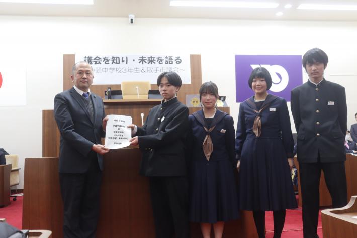 生徒議長から可決された議案を取手市議会の岩澤議長に手渡しする様子