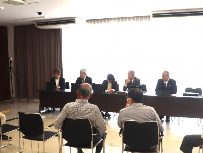 会議室で男女の議員が机に座って、数名の市民から意見を聞いている