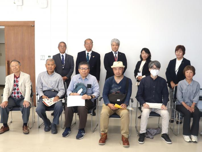 会議室で男女の議員と市民数名が並んいる