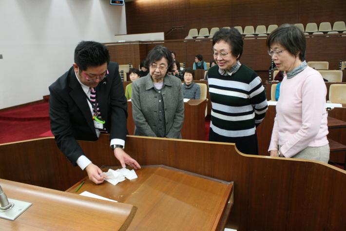 壇上に眼鏡をかけた短髪の女性3人と男性1人が立ち、机上の投票用紙を見ている