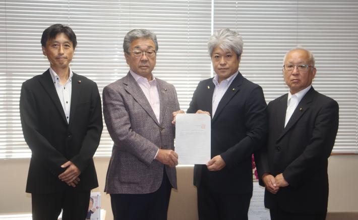 提言書を市長に渡す議長。写真は左から海東委員長、中村市長、山野井議長、小堤副委員長