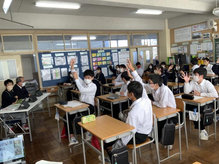 議会クイズに積極的に参加し、挙手する生徒たちの写真