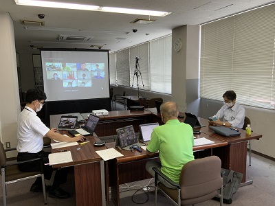 ヤマハYVC-1000を活用したオンライン委員会(総務文教常任委員会)会議室にコの字に着席した3人がPC画面を見ながら作業中。