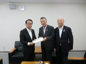入江議長が茨城県市議会議長会会長に報告。手渡している。