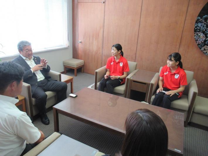 筑波大学生表敬訪問応接室での報告。椅子に座る男性と女性2人