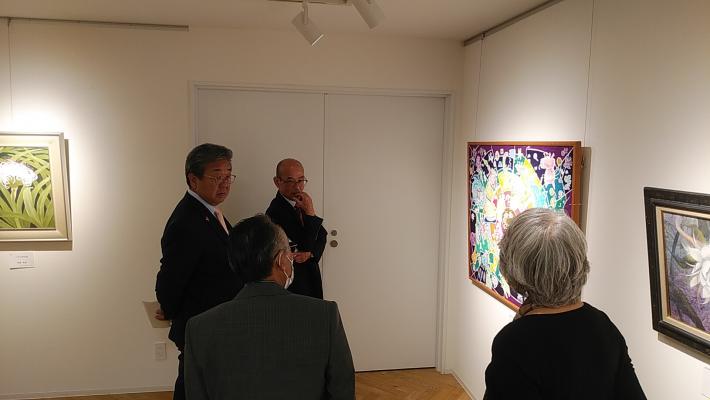 ギャラリーにて展示絵画を眺める市長と教育長。案内をする展示者2人