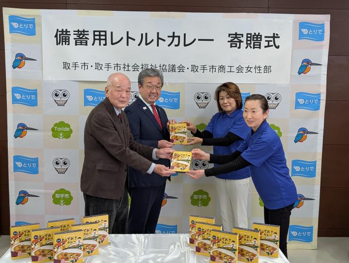 取手市商工会女性部からの物品受領式に参加する市長