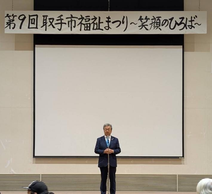 ステージ上にて市民の前で挨拶をする市長