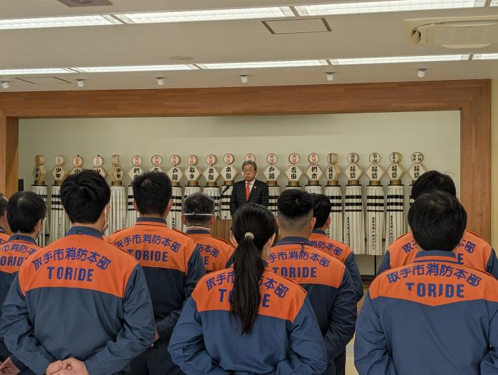 消防の制服を着た人たちに話す男性