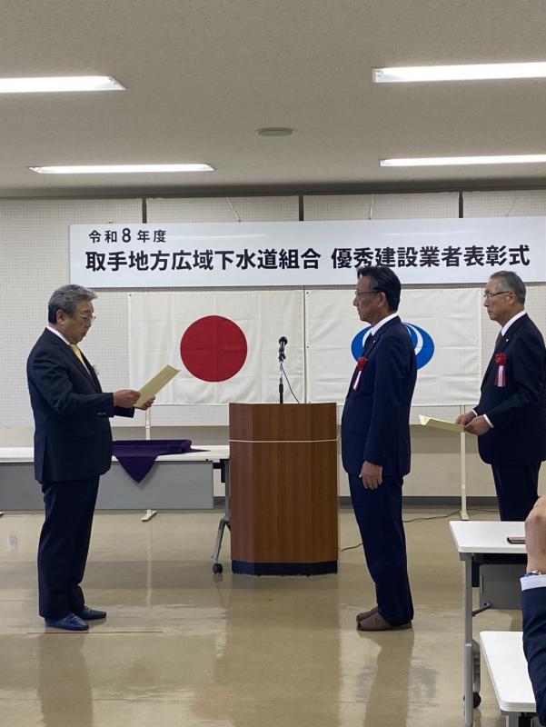 賞状を読み上げる男性と受け取る男性