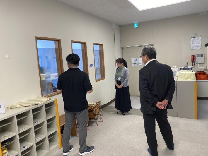 室内の窓から隣の部屋をのぞく人たち