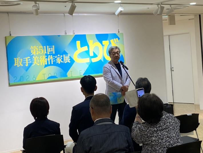 第51回取手美術作家展とりびと書かれた看板の前で話をする男性