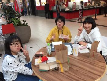 3人の女性の派遣団学生が昼食を食べている様子
