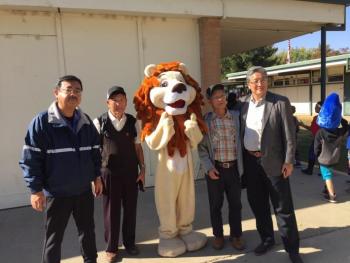 学校体験に合流した一般派遣団員たちが学校のマスコットであるライオンの着ぐるみと記念撮影