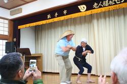 ユーバ市訪問団が日本人とステージ上で踊っている様子