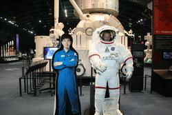 ユーバ市訪問団が宇宙服の看板から顔を出している様子