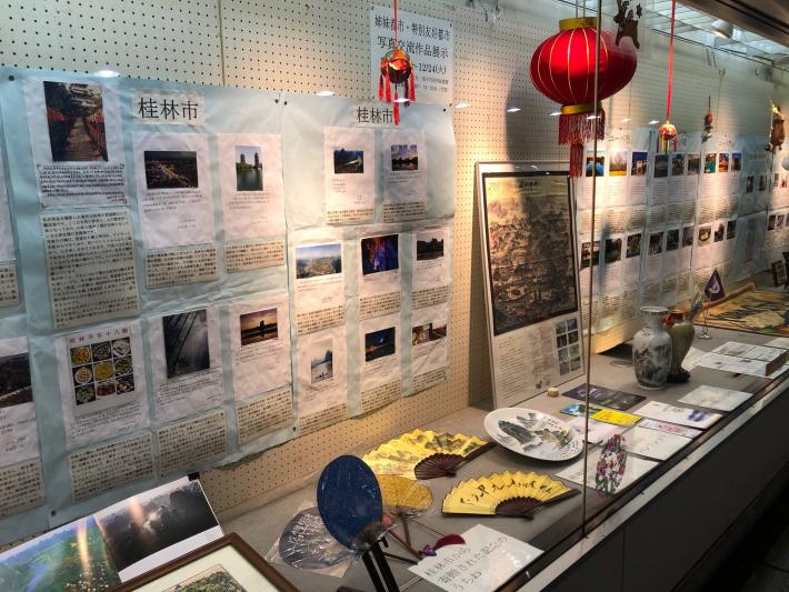 壁に掲示したユーバ市・桂林市の学生が作成した作品と床に置かれたユーバ市・桂林市から寄贈された記念品