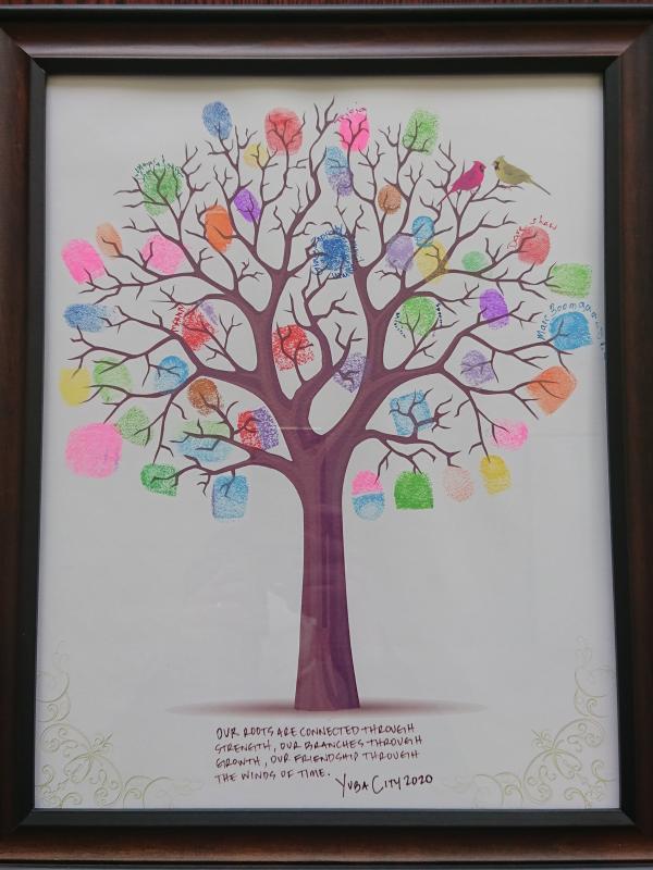 ユーバ市から届いた木をモチーフにした絵。ユーバ市の関係者による色とりどりの指紋で木の枝が飾られています。