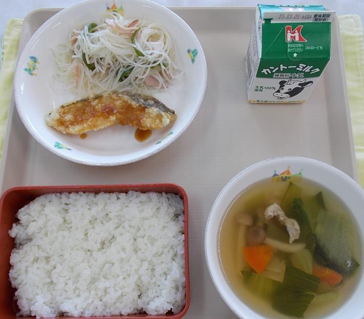 揚げ魚、ビーフン炒め、青野菜や人参が入ったスープ、米飯、牛乳がお盆にのっている