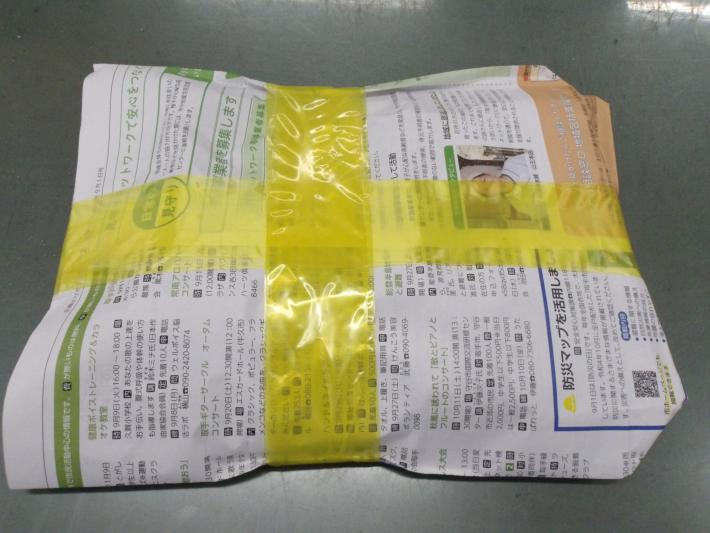 雑紙袋が黄色いひもで十字に縛られている。