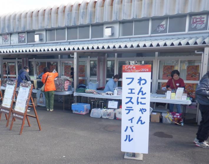 わんにゃんフェスティバルと書かれた看板が立っている。後ろにおかれた机には箱が置かれている