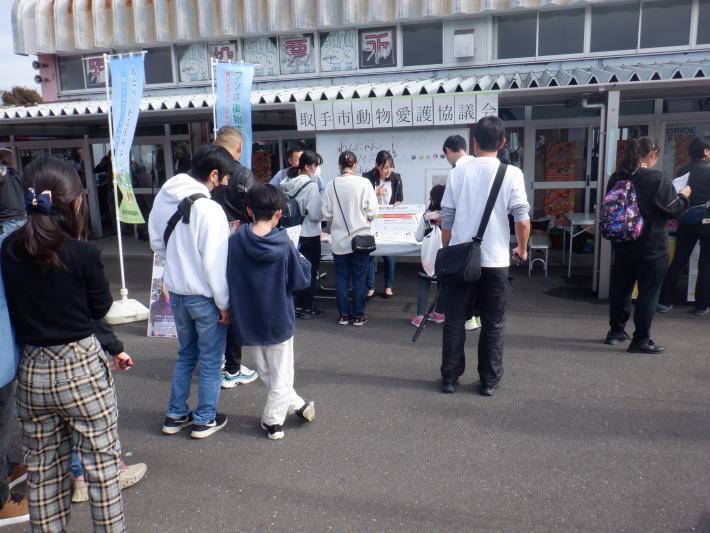 高木真備さんのクイズ大会の様子。女性が机の前におり、周りに人だかりができている