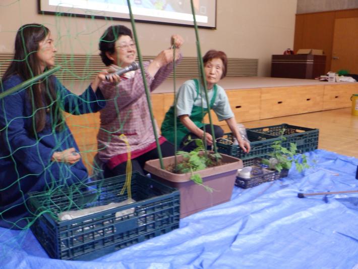 講師が園芸用具を使って緑のカーテンづくりを実演している様子