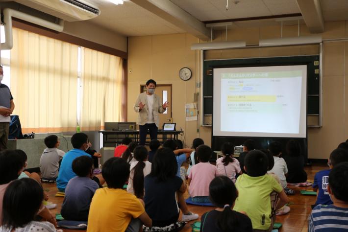 講師の話を熱心に聞く小学生の後ろ姿の写真