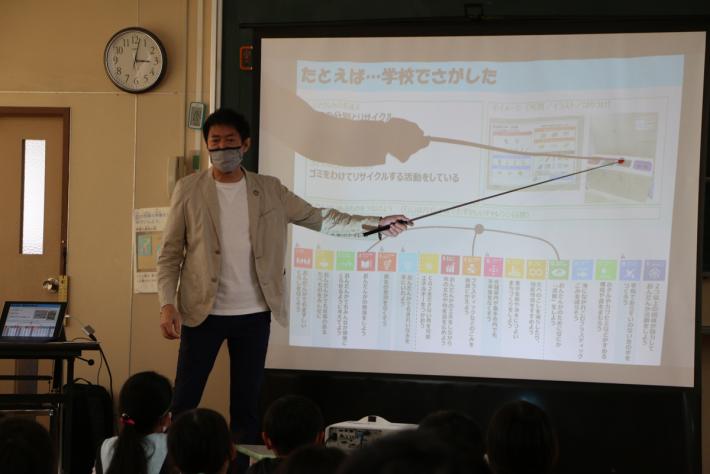 講師がスクリーンに書いてあることについて指している写真