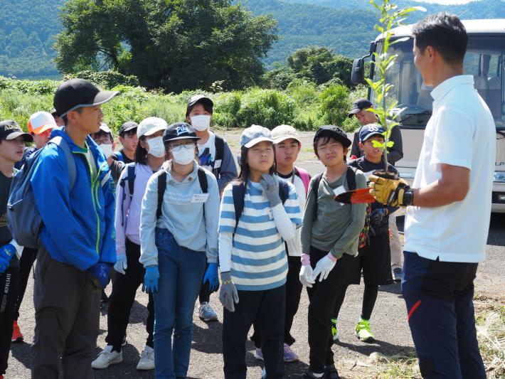 現地添乗員から植樹の説明を聞くこどもたち