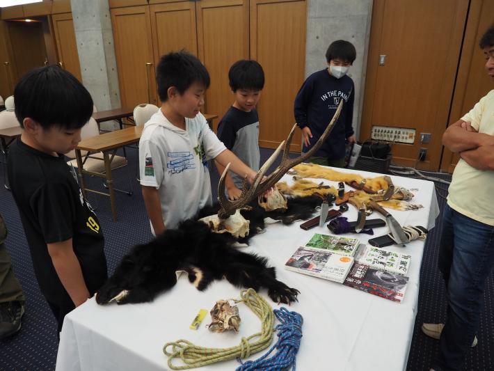 狩猟の道具を見ているこどもたち