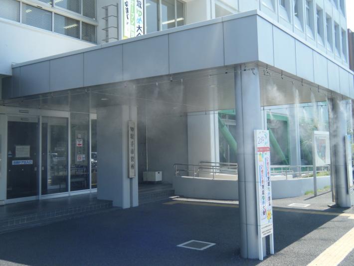 本庁舎玄関前の屋根からミストが噴出されている様子