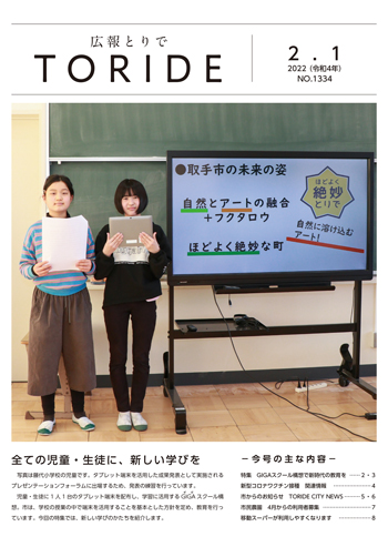 広報とりで2月1日号の表紙。タブレットや資料を持った児童二人が、大型モニターの脇に立っている。