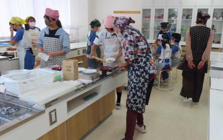 白山小学校の地域ボランティアの皆さんが調理実習を支援する様子
