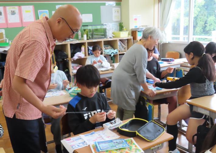 手縫いに挑戦する取手西小学校5年生を西小スマイルサポーターが手伝う様子