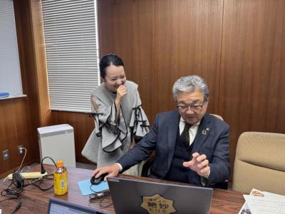 さくらまやさんと市長がパソコンの写真を見ながら審査をしている様子