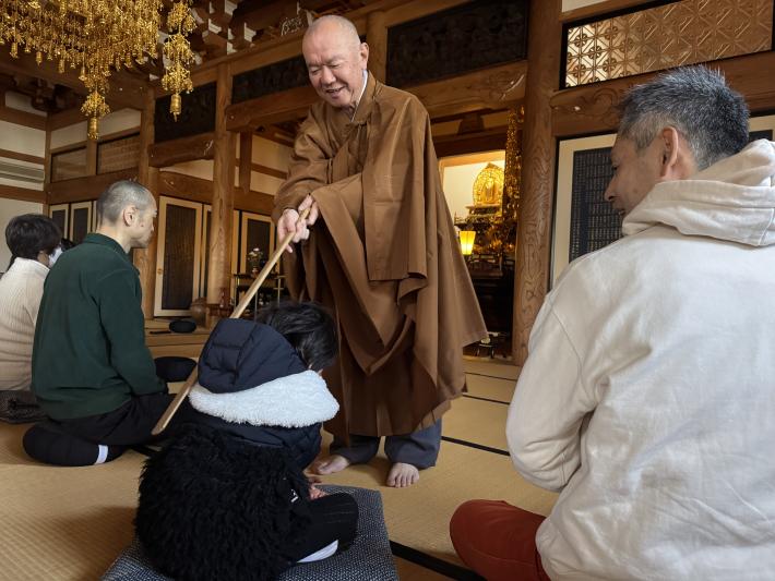 子どもが住職に肩をたたいてもらっている様子