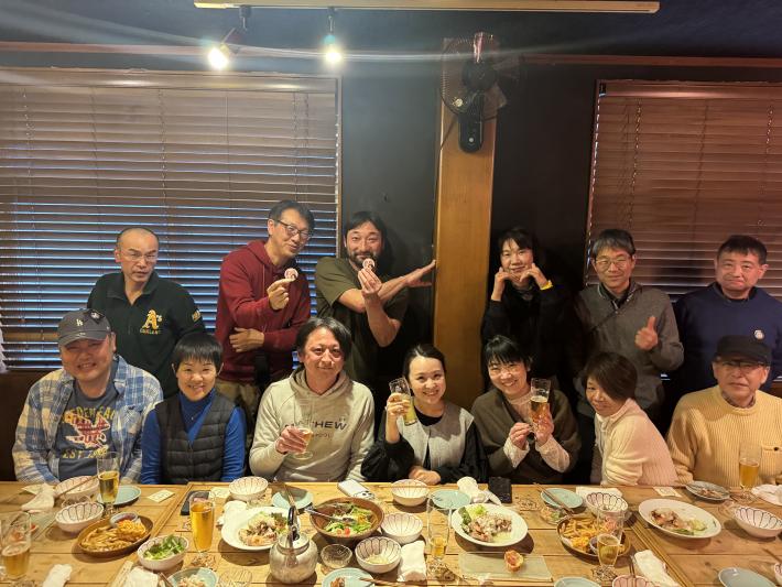 飲食店でさくらまやさんを中心に集合写真を撮っている様子