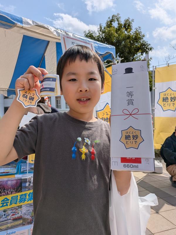 男の子が一等賞の景品とシールを持っている様子