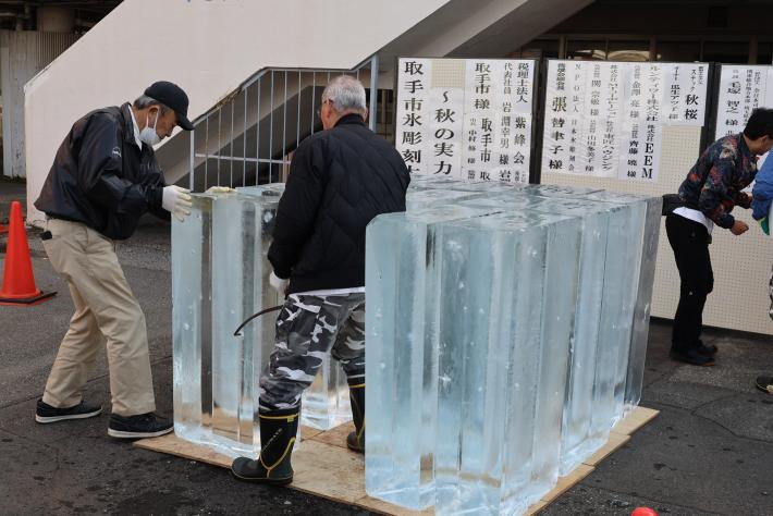 大きな氷を男性二人が運んでいる様子
