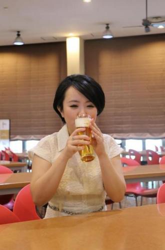 生ビールをおいしそうに飲む若い女性の写真