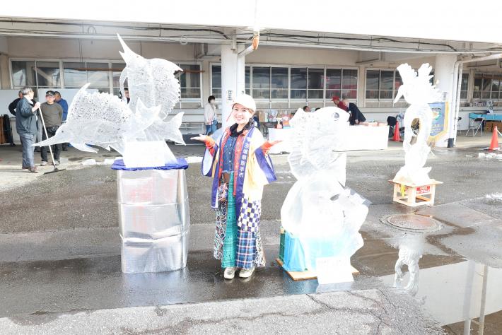 氷彫刻の前でポーズをとるさくらまやさん