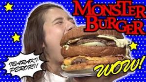 動画サムネイル：顔よりも大きなハンバーガーにかぶりつく女性の写真「MONSTER BURGER WOW!」の文字