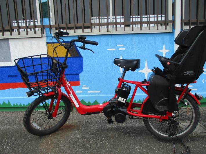 チャイルドシート付の赤い電動自転車が1台写っている