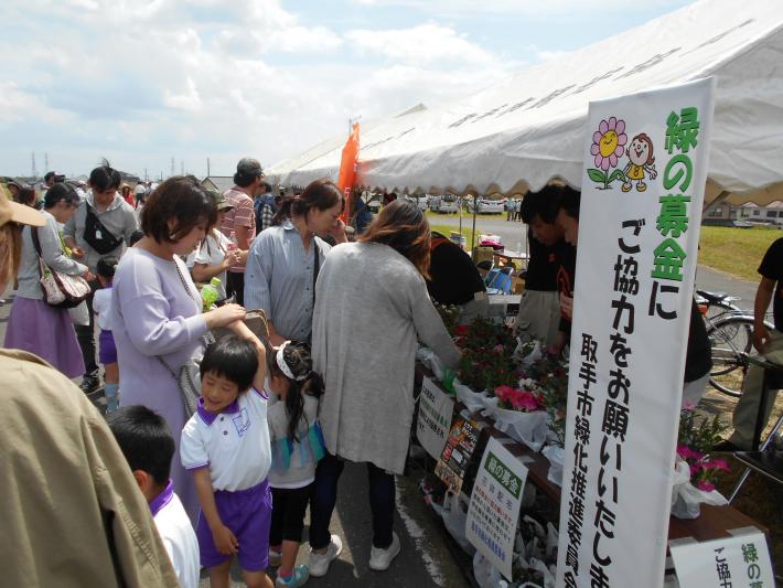 緑化イベント（フラワーカナル）の様子。緑の募金にご協力くださいのとたてられたテントの前に大勢の人がいる