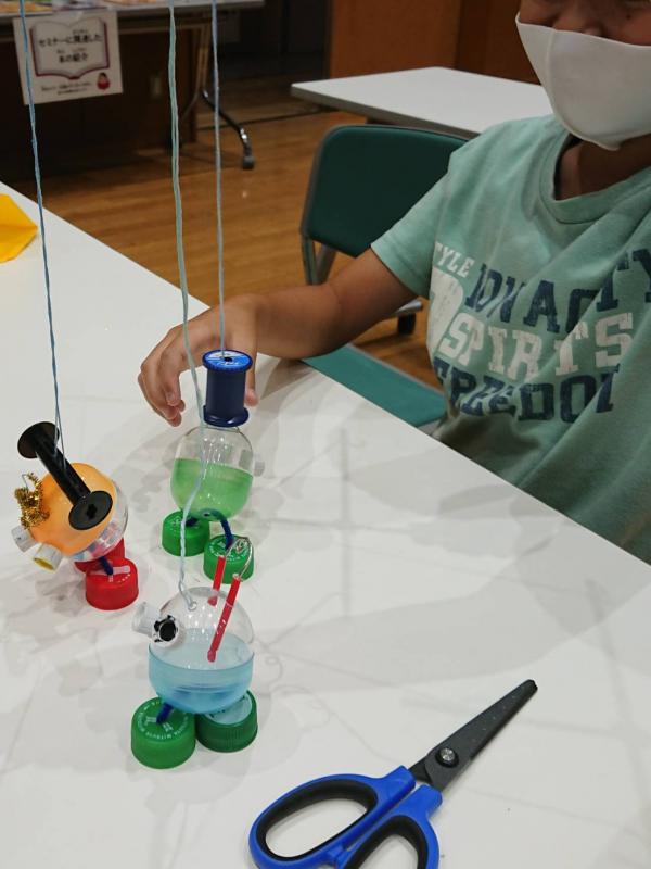 小学生男子が作ったロボット型のマリオネットを吊り下げている写真