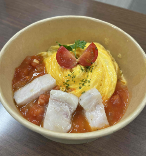 オムライスの上に、ミニトマトとパセリ、バナナポークが乗っています