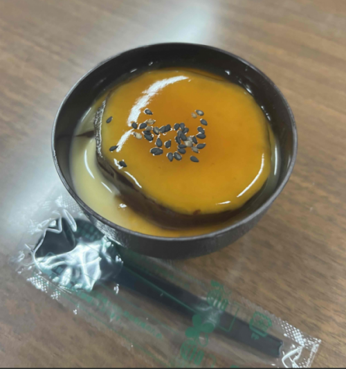 プリンの上に焼き芋が乗り、みたらしソースとごまが振られています。