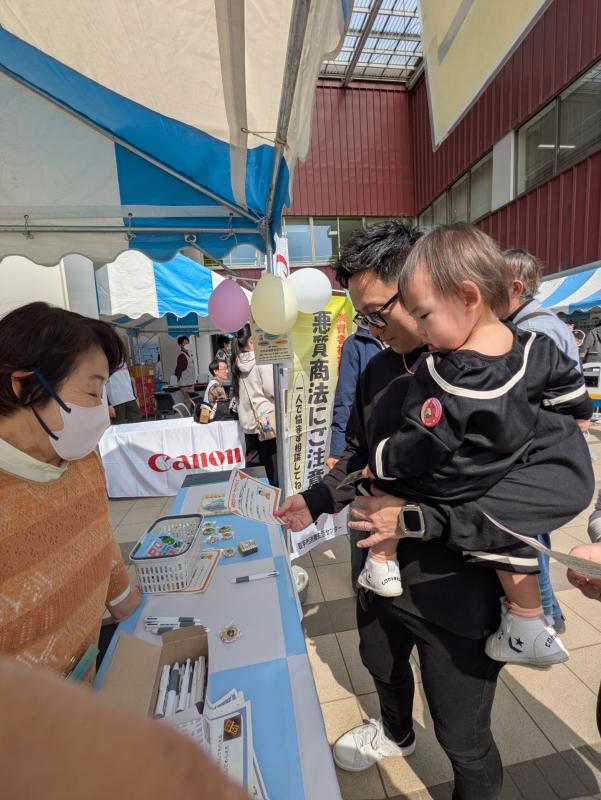 お父さんと子どもがクイズの答えを考えている写真